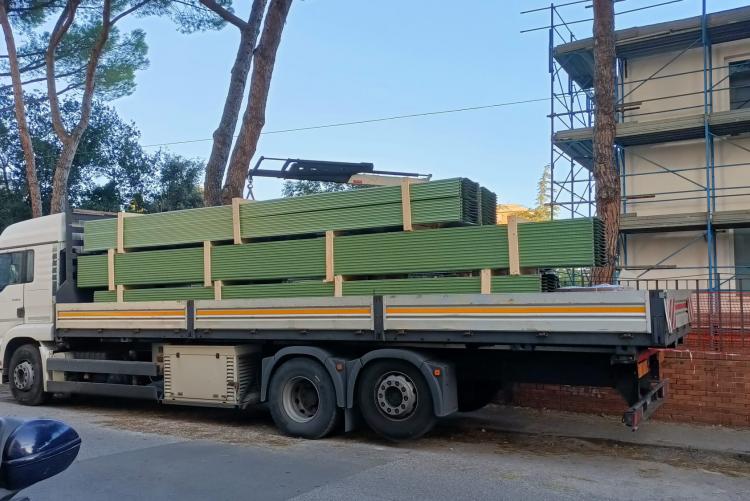 il camion mentre scarica il materiale necessario per la copertura della scuola Pazzini